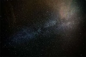 Dense star field with a pale band of the Milky Way against a dark background.