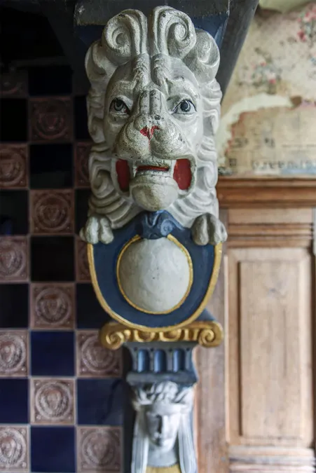Detalle de una cabeza de león pintada en la chimenea