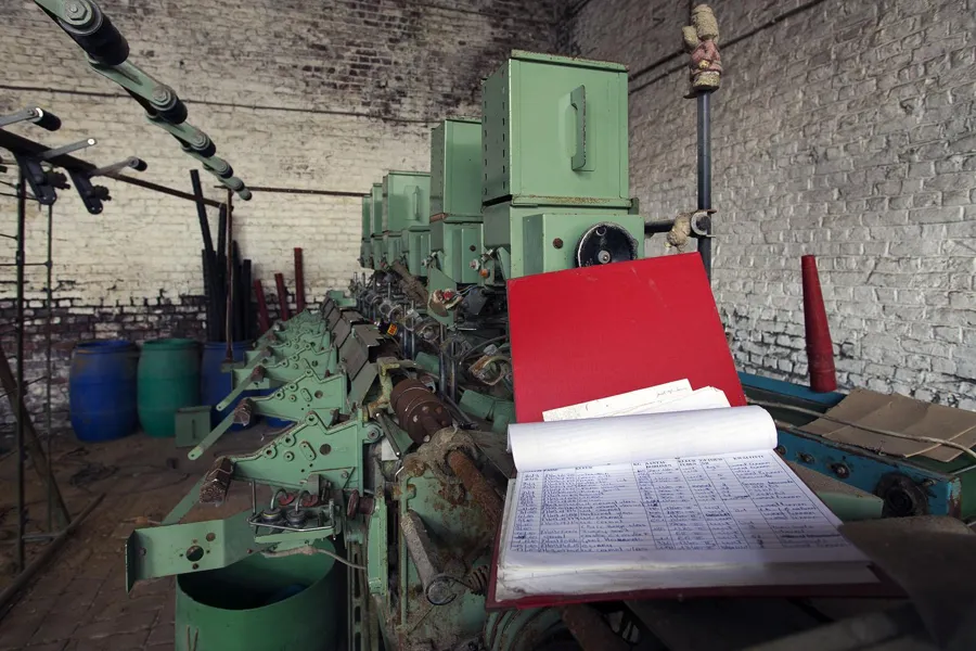 Máquina verde con carpeta abierta de esquemas en primer plano.