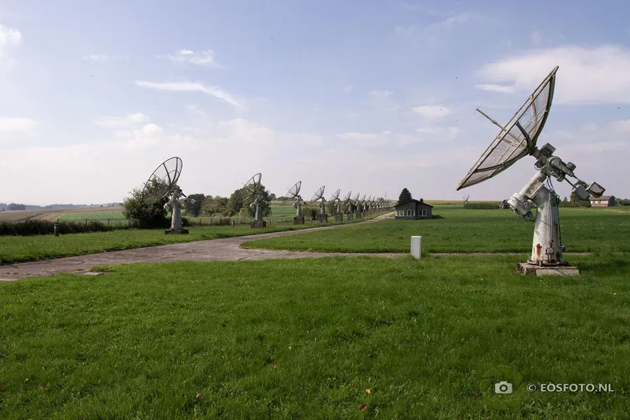 Large dish antenna right with smaller antennas scattered across the grass.