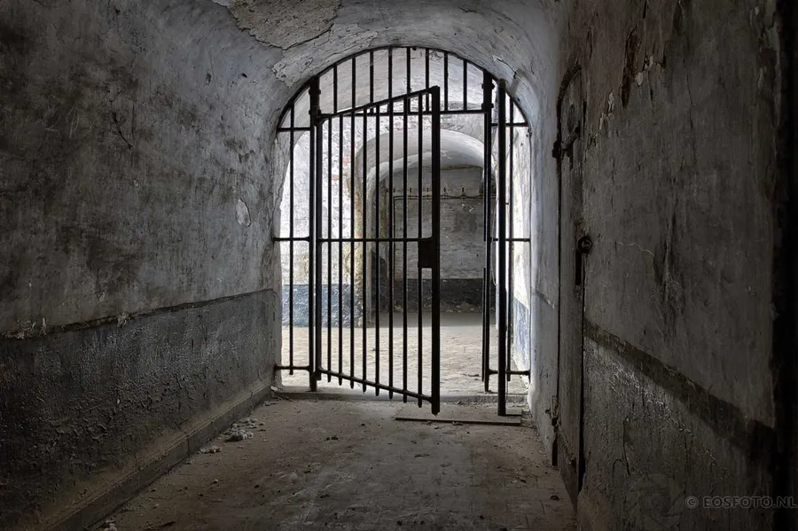 Metal barred gate in a vaulted passage.