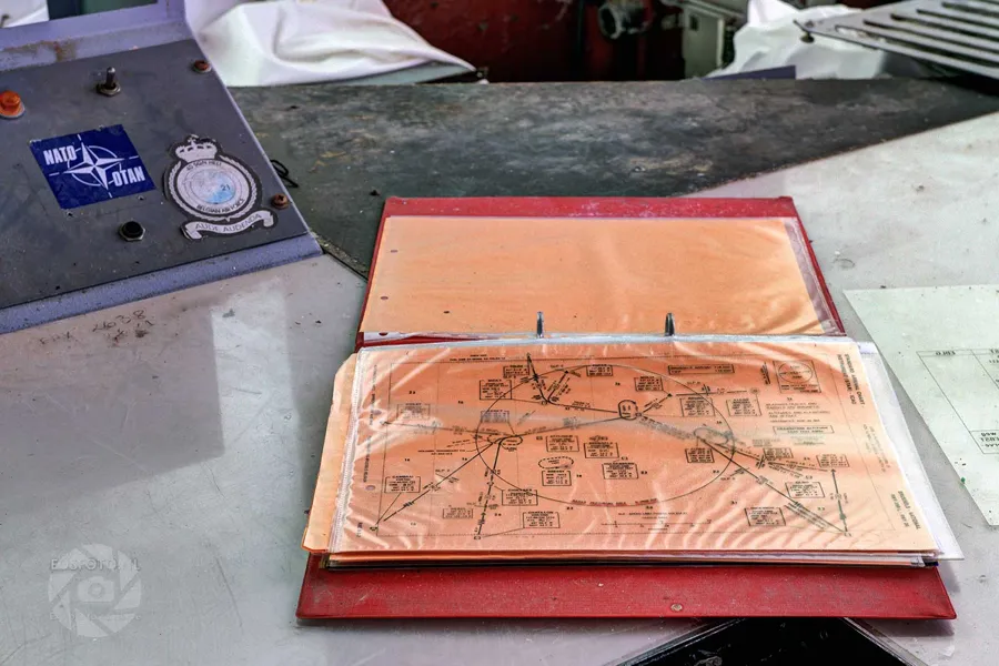 Open red folder with technical drawings on a weathered work desk.