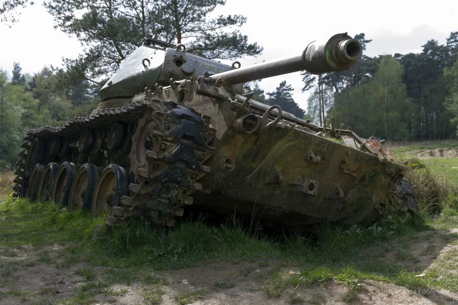 Rostender Panzer mit Kanone nach rechts und lose herabhängender Kette vorne.