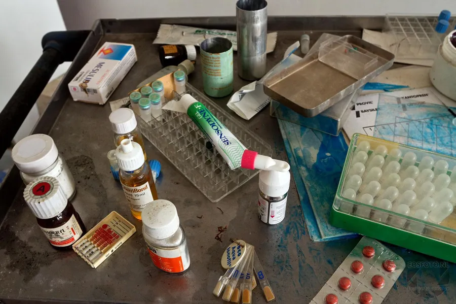Loose bottles, pill packaging and metal trays on a worktop.