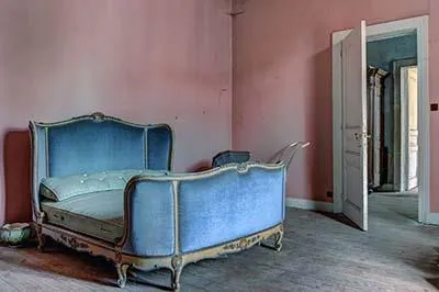Lit capitonné bleu dans une chambre rose