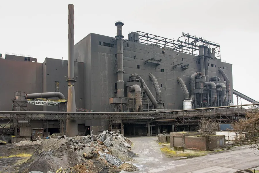 Steelworks with large ducts and rubble heaps in the foreground.