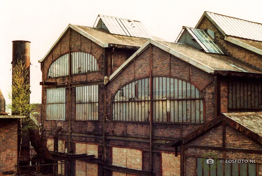 Naves industriales de ladrillo con ventanas altas arqueadas y tragaluces de vidrio.