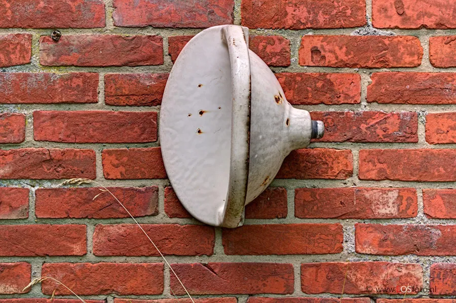White ceramic washbasin on an exterior red brick wall