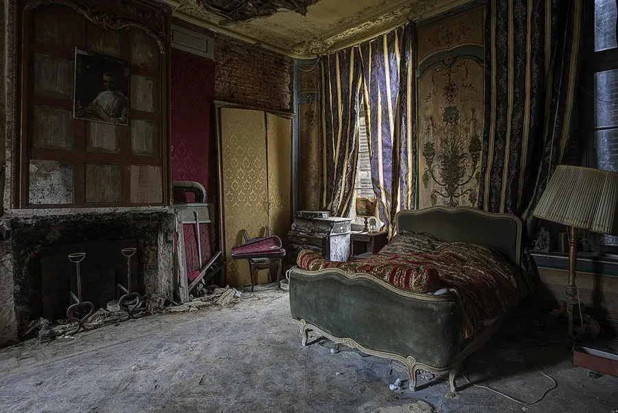 Bed opposite a fireplace in an elaborately decorated room