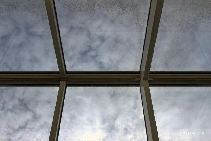 Nubes tras los cristales de un techo acristalado.