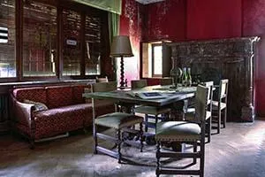 Mesa y sillas junto a un sofá rojo en una habitación de paredes rojas