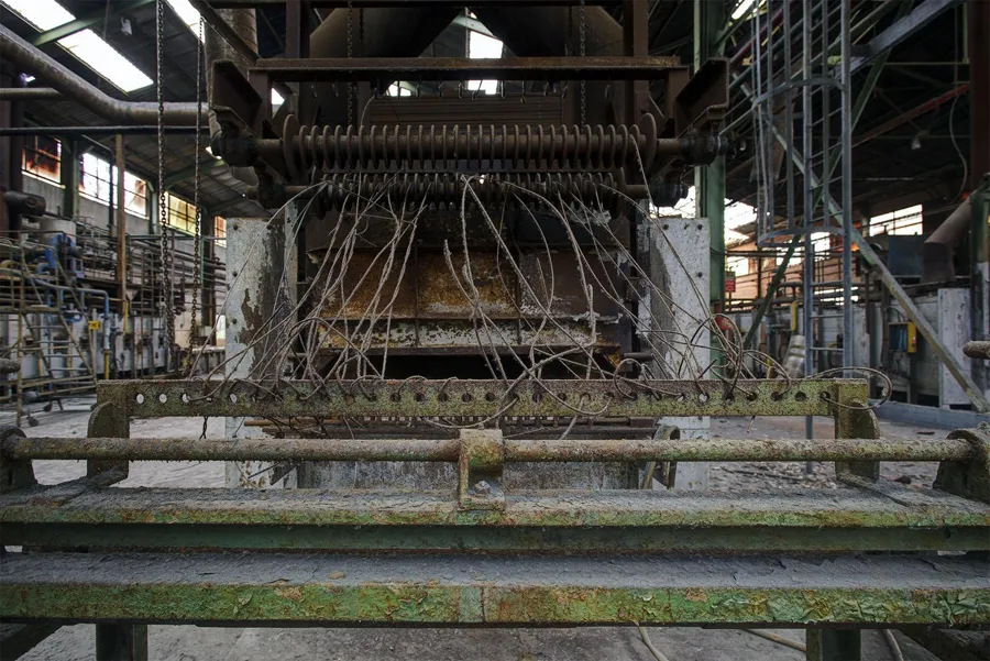 Losse draden door een brede stoffige machine.