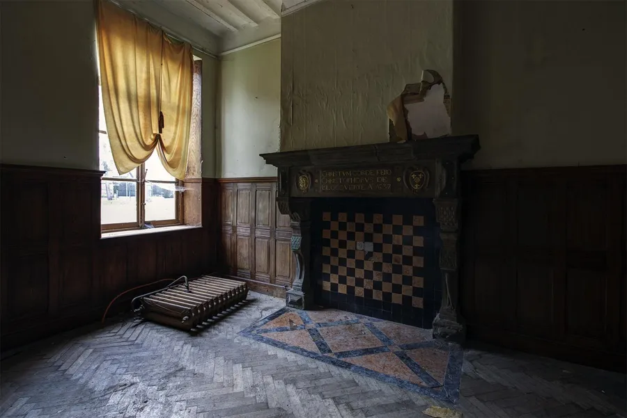 Chimenea pequeña con azulejos de damero junto a una ventana