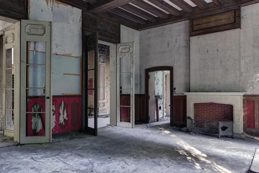 Pièce vide avec portes ouvertes et cheminée maçonnée