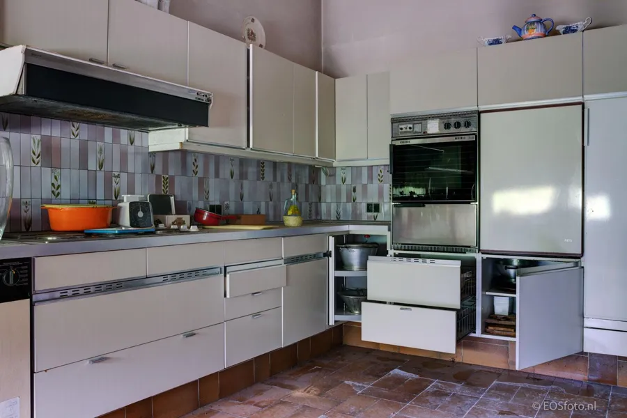 White kitchen with open drawers and cupboard doors.