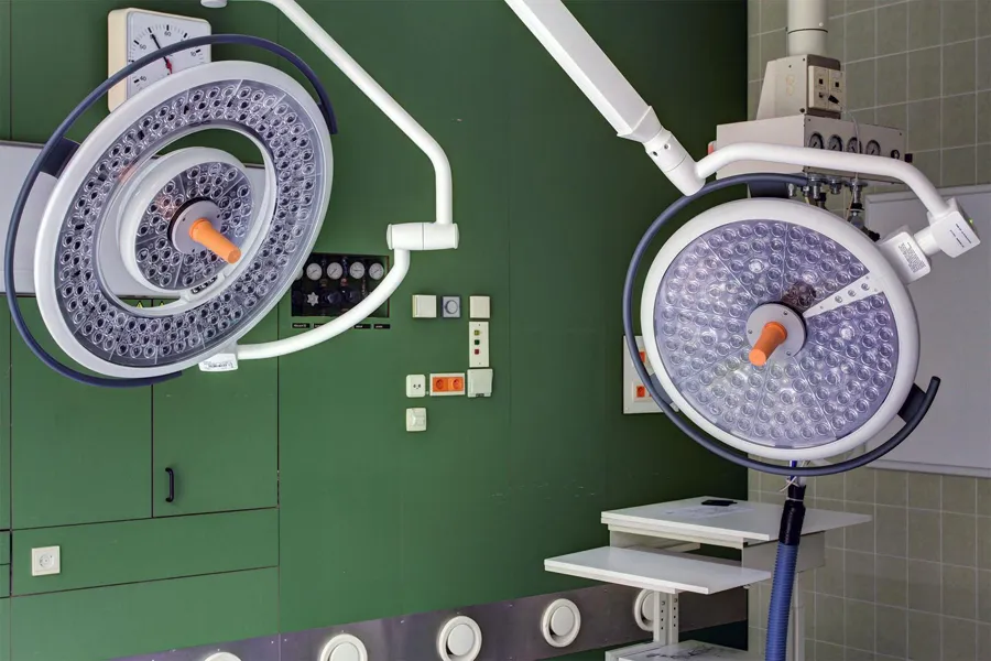 Two round surgical lights with orange handles.