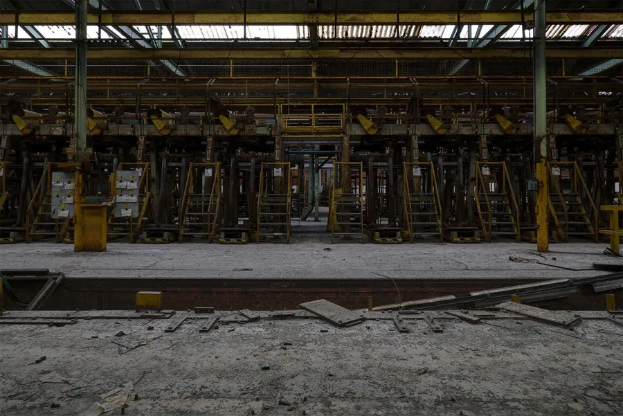 Rij stoffige machines achter gele leuningen.