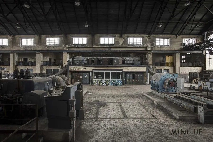 Machine hall with two heavy installations and a glazed control room at the back.