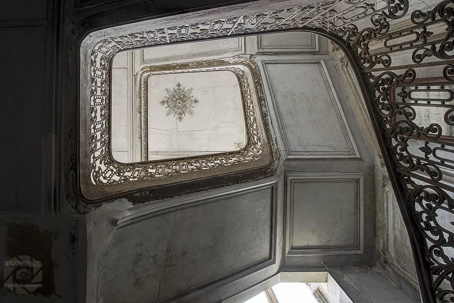 View upwards along ornate metal stair railings