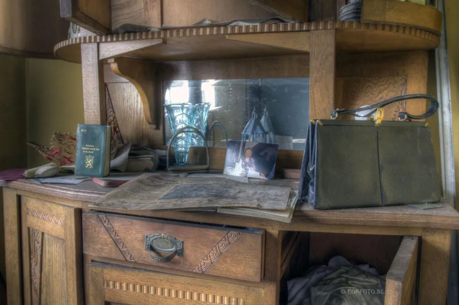 Staubiges Holzsideboard mit Spiegel, Fotos und Tasche.