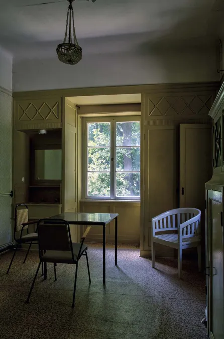Kamer met tafel, losse stoelen en een hanglamp