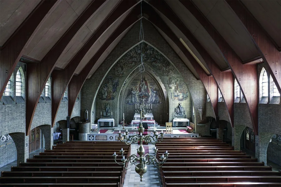 Elevated view of the church with pews, a chandelier and large paintings around the altar.