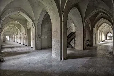 Two vaulted corridors meet beside a central staircase.