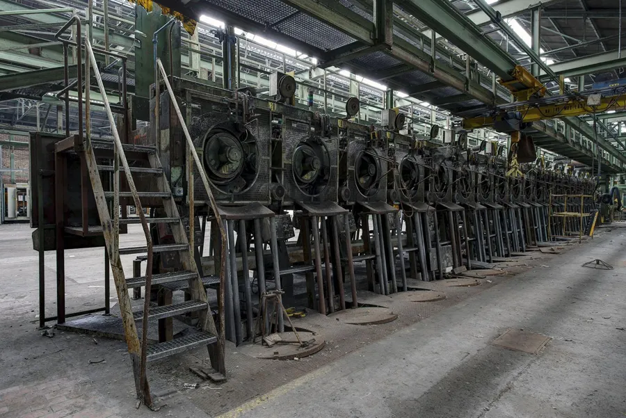 Houten ladder naast een lange rij ronde machines.