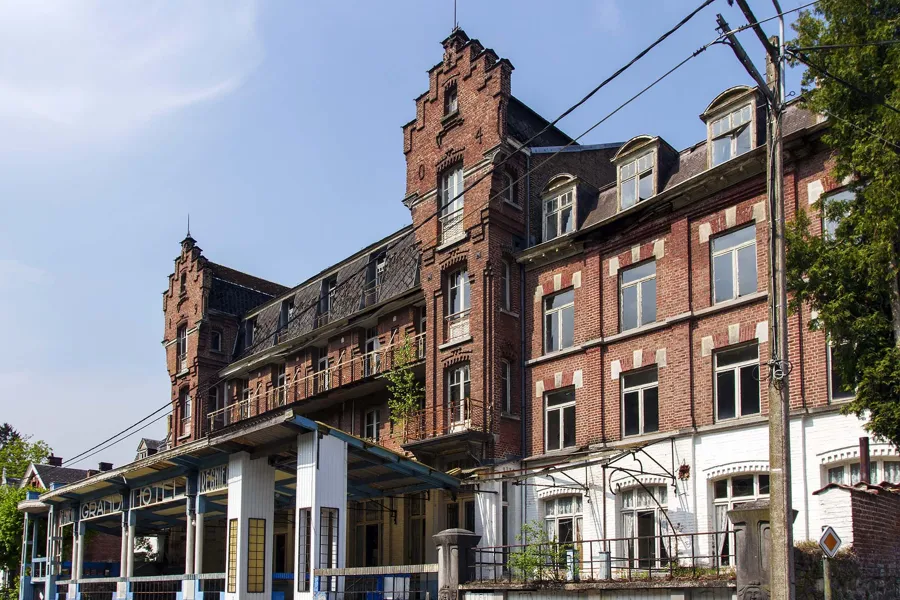 Long brick hotel façade with tall gables and a low veranda.