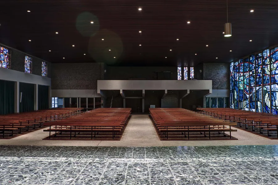 View from the altar side across the pews towards the gallery and glass wall right.