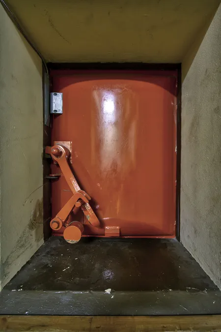 Gesloten rood metalen luik met een groot vergrendelingsmechanisme.