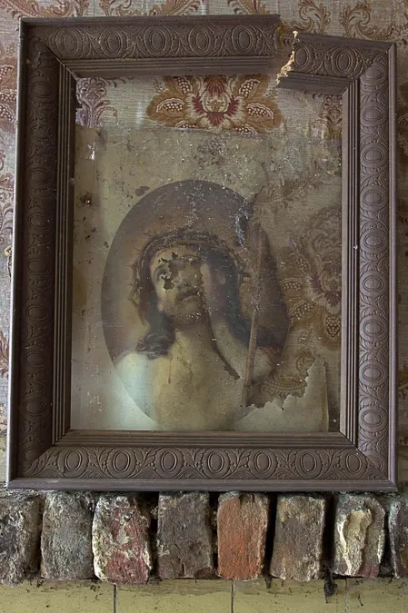Framed image of Jesus with a crown of thorns above exposed bricks