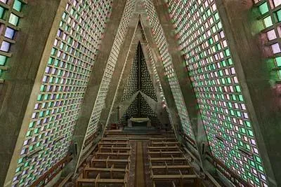 Wide view of the triangular church with pale green glass walls.