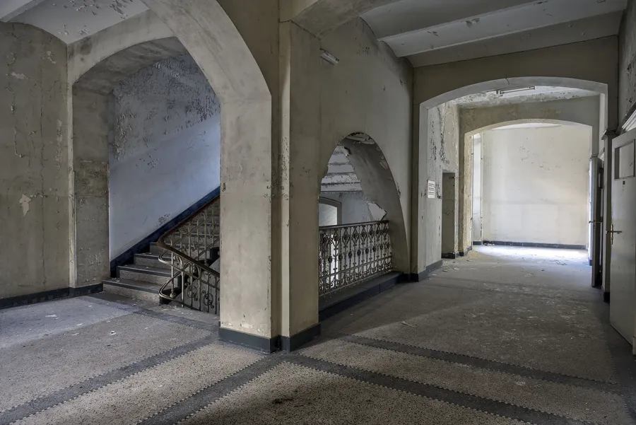 Paso abovedado con escalera izquierda y puerta luminosa derecha.