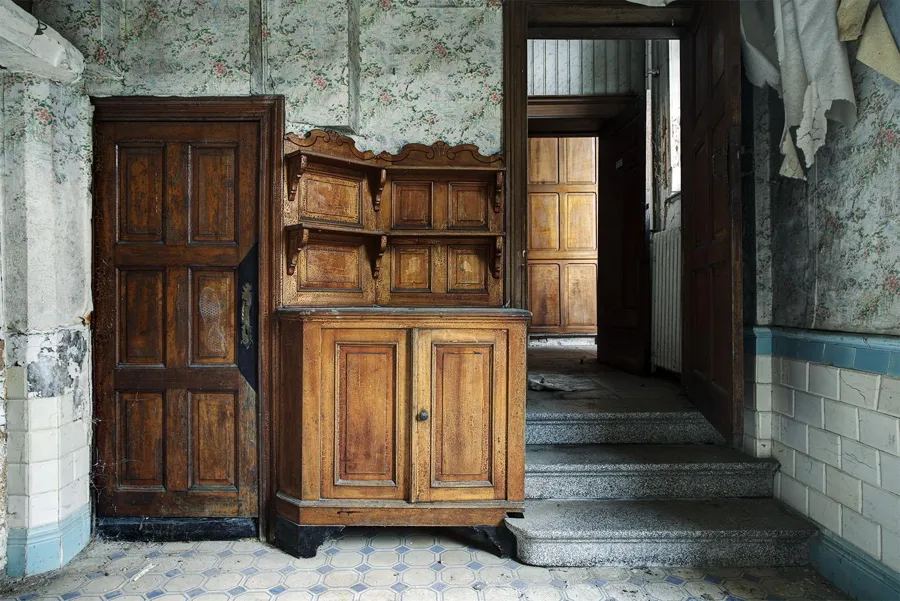 Armario de madera junto a una puerta y unos peldaños de piedra
