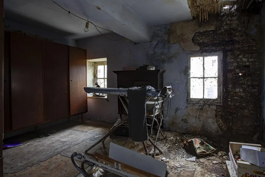 Zimmer mit hohem Schrank und Metallgestell an einem Fenster