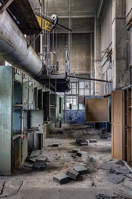 Tall plant room with open cabinets and rubble on the floor.