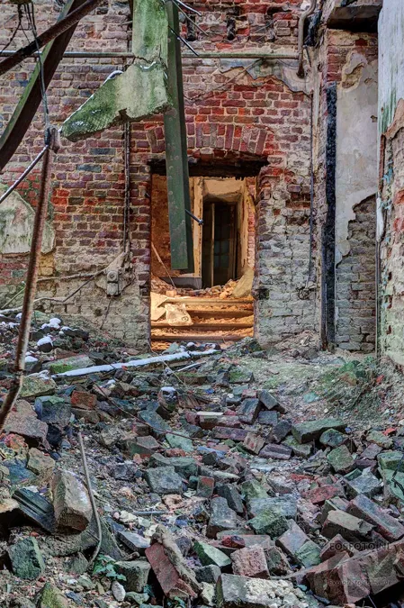 Offene Ruine mit Backsteinmauern und verstreuten Balken