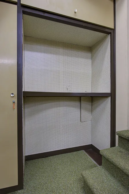 Open lege wandkast met witte binnenwanden en een houten legplank.