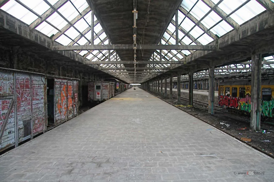 Tiefer Blick durch eine Bahnhalle mit Graffitiwagen links.