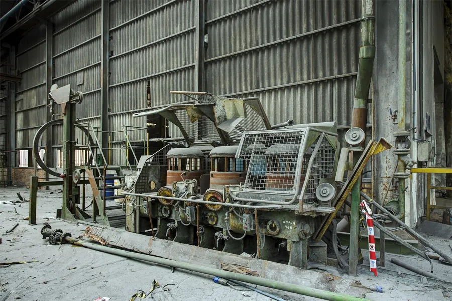 Stoffige machine met ronde rollen achter beschermgaas.
