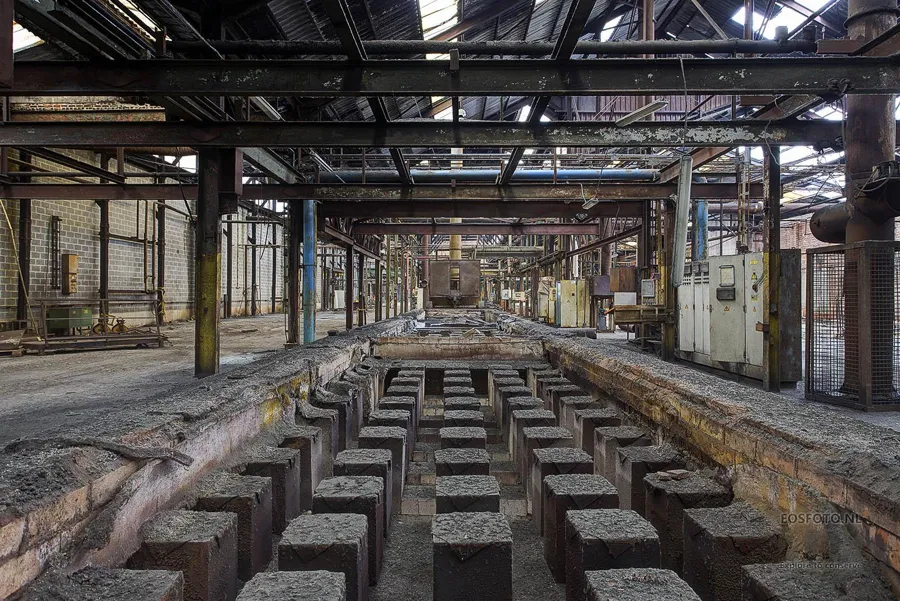 Lange open werkput onder een stalen draagconstructie.