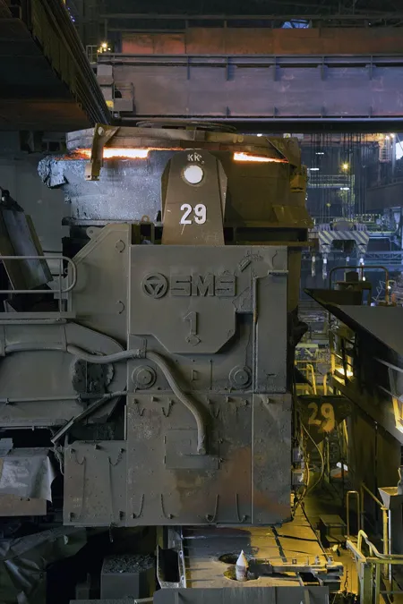 Détail vertical d’une machine industrielle sombre portant le numéro 29 en blanc.