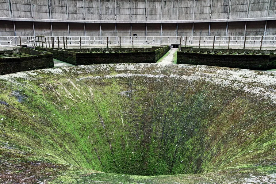 Große trichterförmige Öffnung mit Grünbelag im Kühlturm.