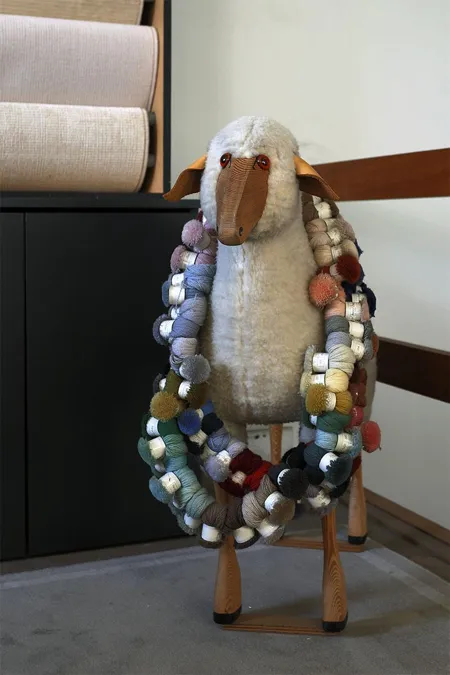 Figurita de oveja decorada con hebras de muestras de hilo de colores.