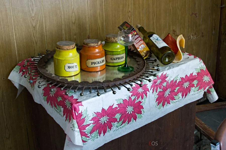 Tarros y botella en una bandeja sobre un mantel floral.