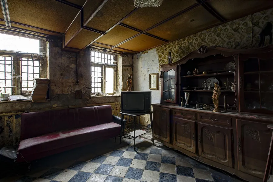 Violettes Sofa, Fernseher und Holzbuffet auf Fliesenboden