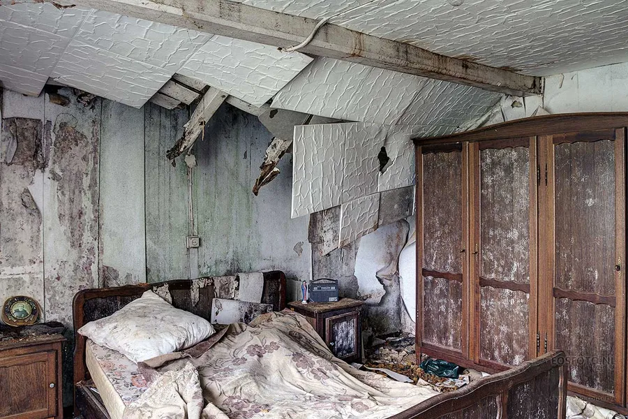Lit et armoire sous de grands pans de plafond détachés