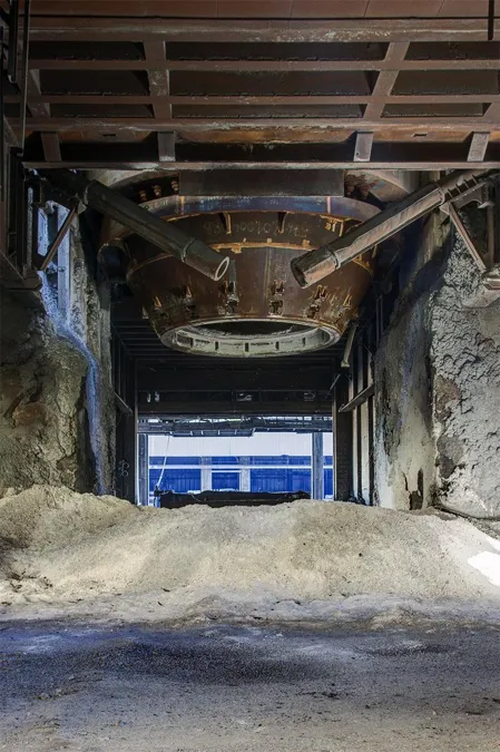 Circular underside of an installation above a narrow concrete passage.