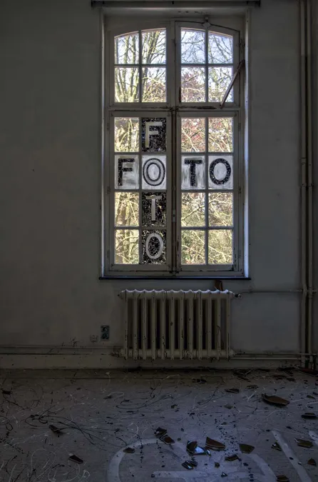 Haute fenêtre aux lettres séparées sur les vitres et gravats au sol.
